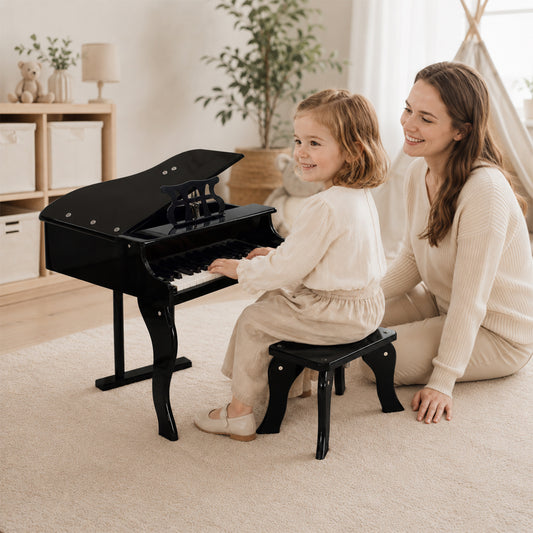 Mädchen spielt auf einem schwarzen Mini-Flügel Kinderklavier mit passendem Hocker
