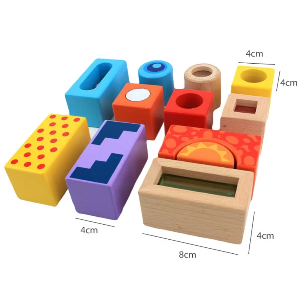 Kind spielt mit Sound Blocks aus Holz, bunten Klötzen, die beim Bewegen Geräusche erzeugen und die Sinnesentwicklung fördern.