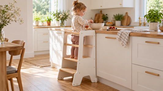 Kind nutzt einen Montessori Lernturm in der Küche an der Arbeitsfläche