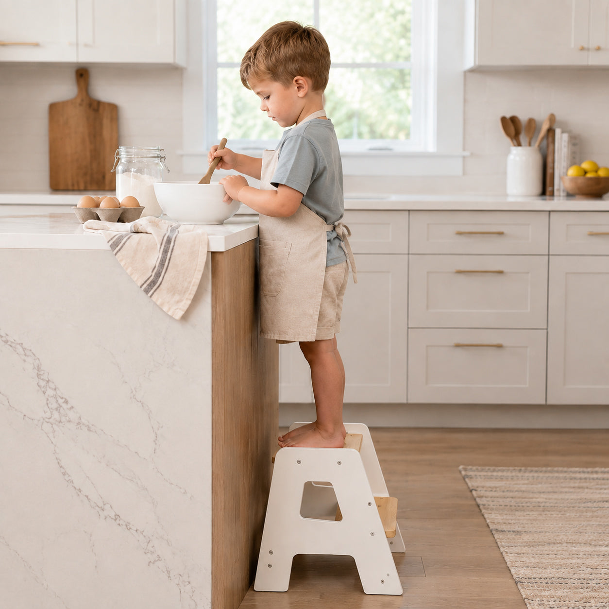 Toddler using a wooden kitchen step stool to participate in cooking activities