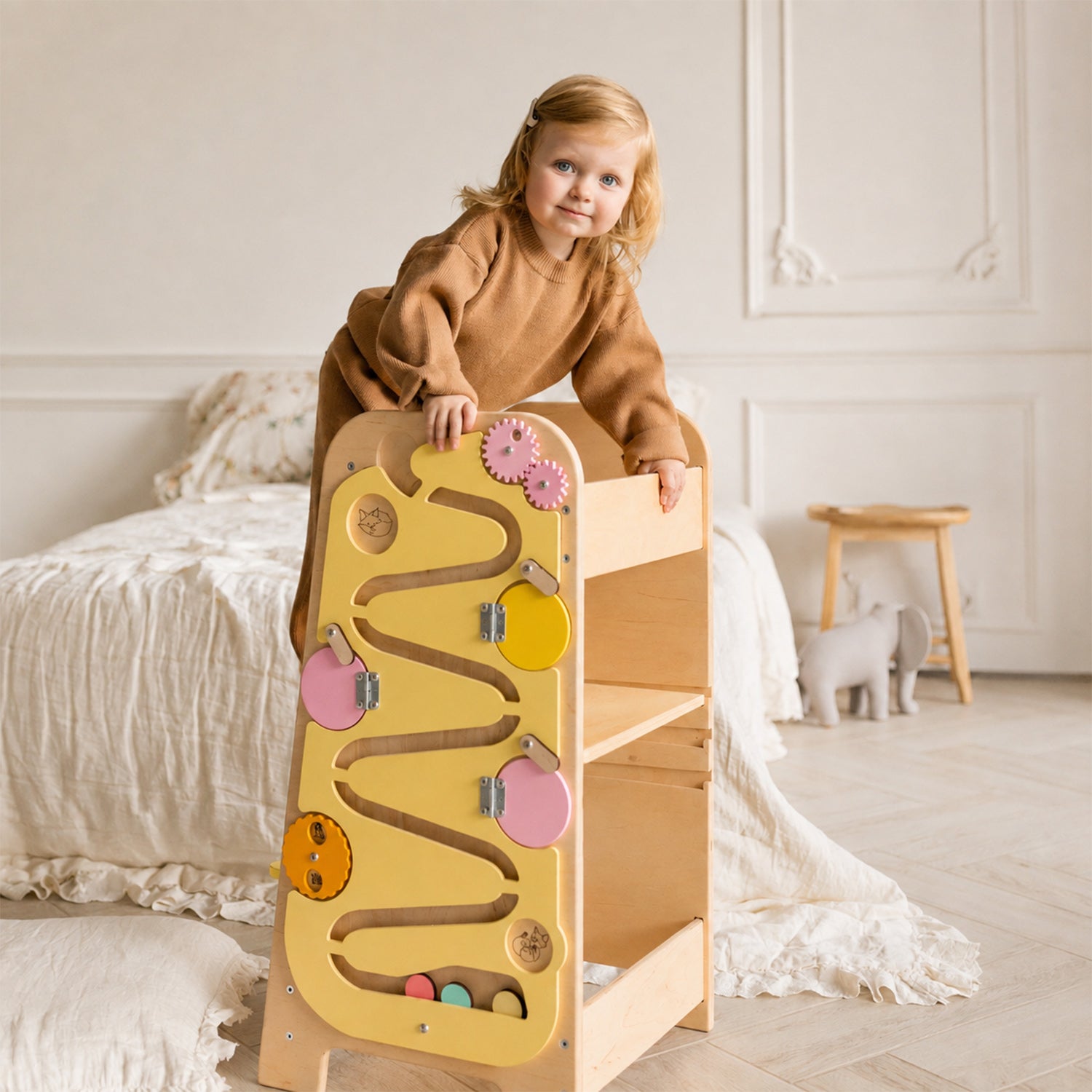 Kind mit multifunktionalem Holz-Lernturm im hellen Kinderzimmer