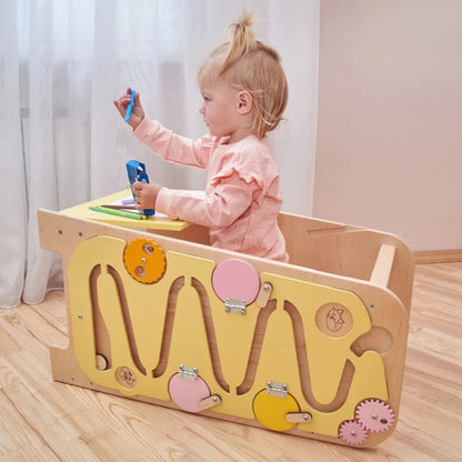 Zum Kindertisch umgebauter Lernturm mit integriertem Busy Board