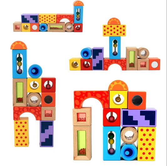 Kind spielt mit Sound Blocks aus Holz, bunten Klötzen, die beim Bewegen Geräusche erzeugen und die Sinnesentwicklung fördern.