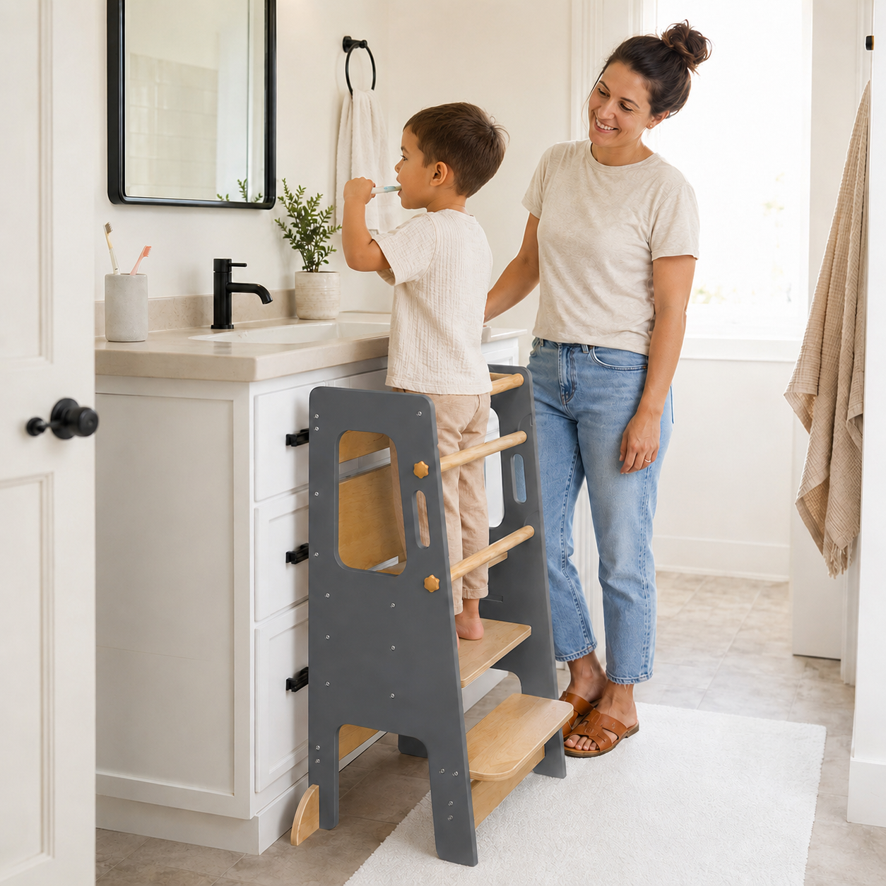 Toddler standing safely on a learning tower to develop independence skills